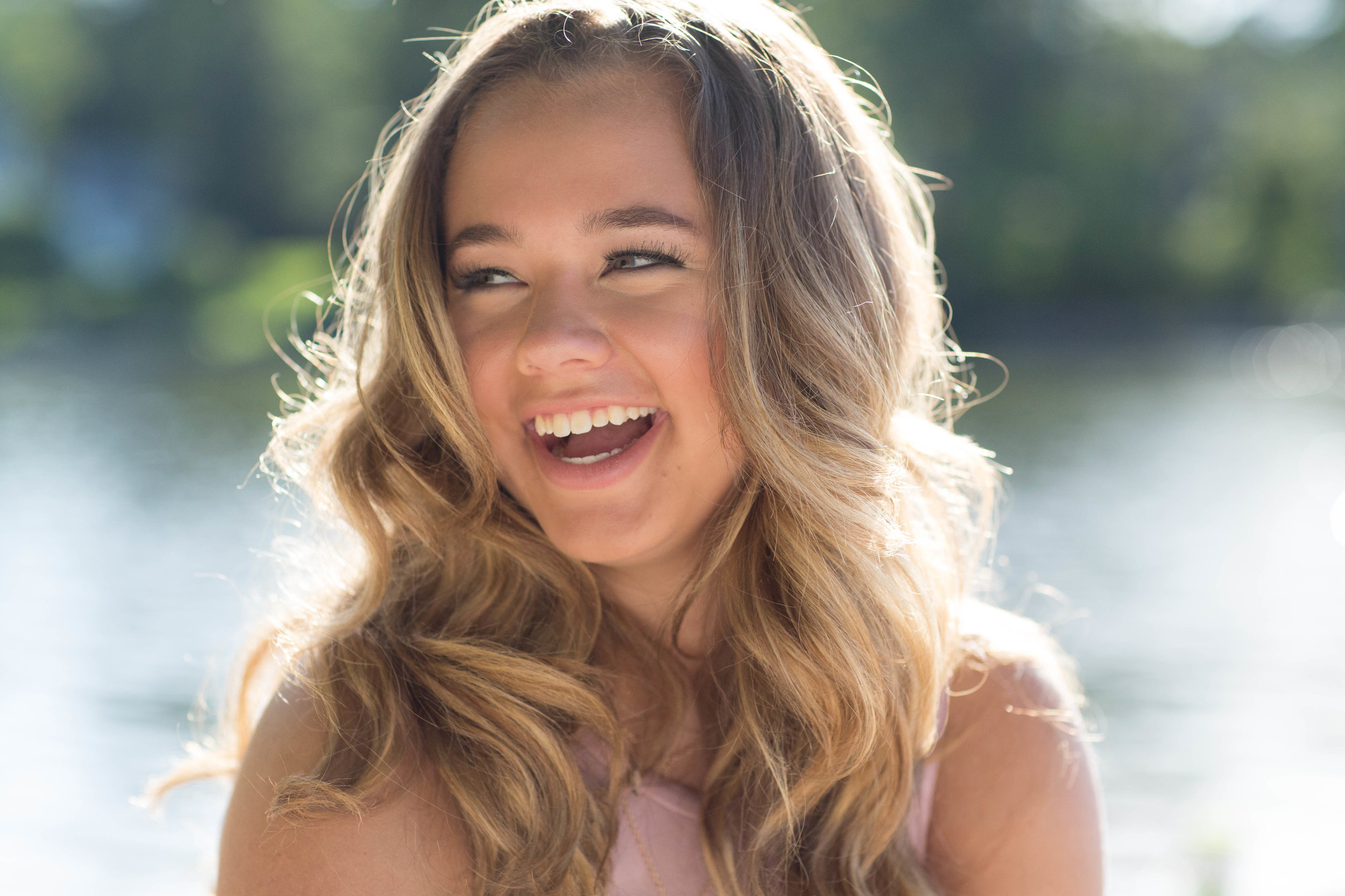 Senior pictures of sunlit girl laughing